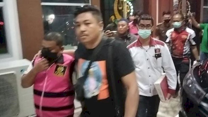 Tersangka mengenakan rompi di Kantor Kejaksaan Negeri Jeneponto dengan pengawalan pihak kepolisian. 