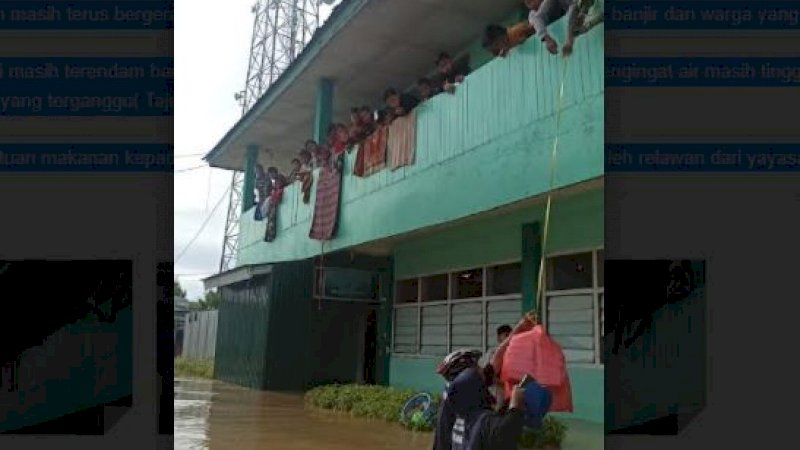 Relawan dari Yayasan Peduli dan Berbagi Pangkep membagikan makanan kepada warga yang terisolasi banjir.