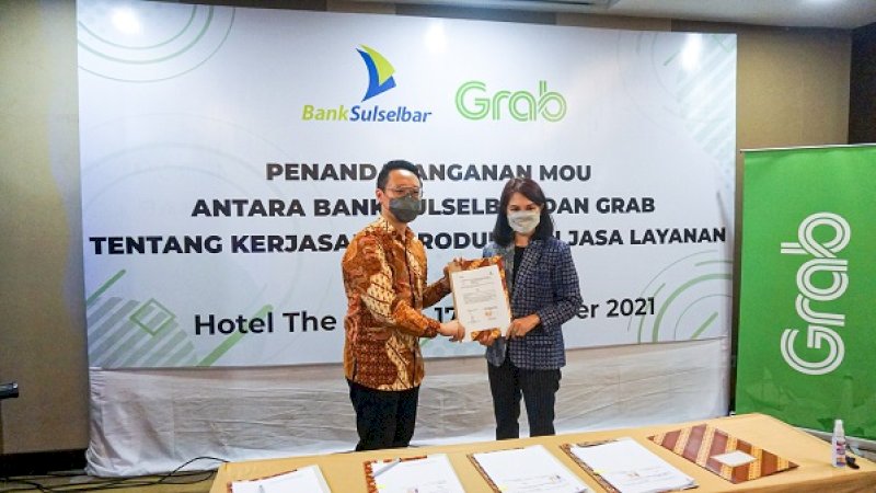 Director of East Indonesia Grab Indonesia, Halim Wijaya (kiri), bersama Irmayanti Sulthan, Direktur Operasional dan IT Bank Sulselbar, usai melakukan penandatanganan kerja sama produk dan jasa layanan Grab for Business.