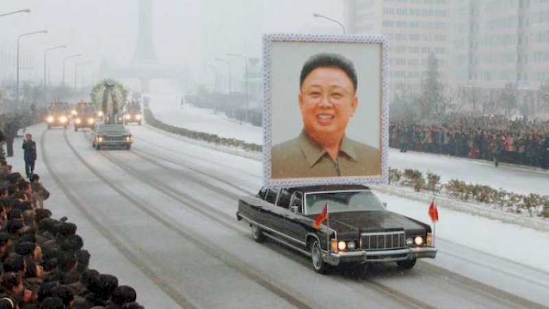 Poster besar Kim Jong Il diarak keliling kota.