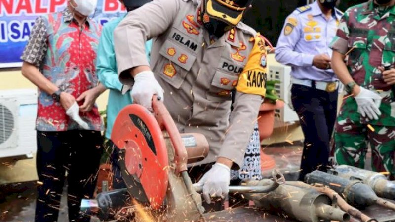 Kapolres Wajo, AKBP Muhammad Islam, memotong knalpot racing menggunakan mesin pemotong.