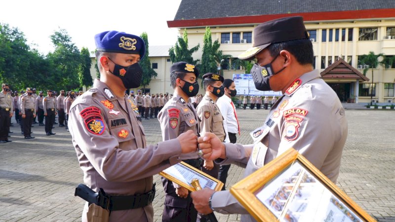 Kapolda Sulsel Irjen Pol. Nana Sudjana  memberikan penghargaan untuk personil Polda Sulawesi Selatan saat apel pagi di halaman Mapolda Sulsel, Senin, (3/1/2022).