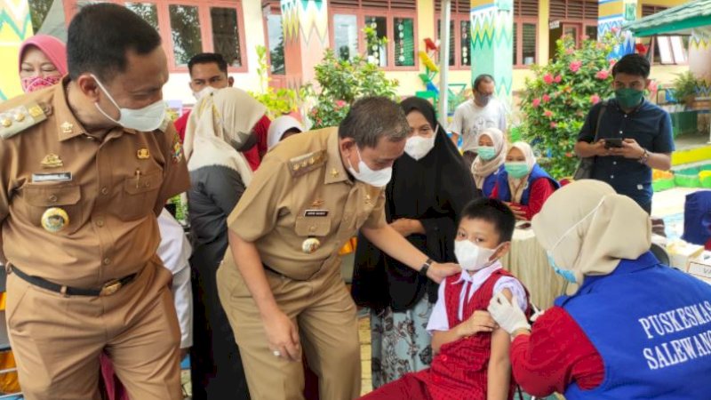 Bupati Wajo, Amran Mahmud, berinteraksi dengan salah satu peserta vaksinasi di SDN 2 Sengkang, Kecamatan Tempe, Selasa (18/1/2022).
