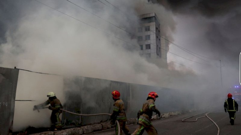 Petugas pemadam kebakaran memadamkan api di sebuah gudang yang terbakar, menurut pihak berwenang setempat, setelah penembakan, saat invasi Rusia ke Ukraina berlanjut, di desa Chaiky di wilayah Kyiv, Ukraina 3 Maret 2022. REUTERS/Serhii Nuzhnenko