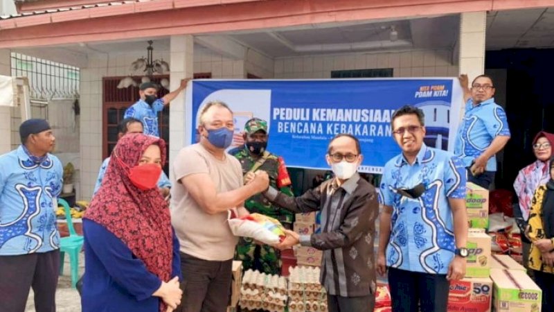 PJ Direktur Teknik PDAM Makassar, Arifuddin Hamarung beserta rombongan membawa sejumlah bantuan sembako yang diserahkan langsung kepada korban kebakaran di Aspol Perintis jl Veteran Selatan, Kamis,(21/4/22).
