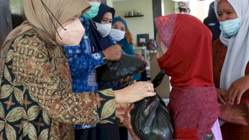 Ketua Tim Penggerak PKK Barru, Hasnah Syam, meyerahkan bantuan pangan berupa berupa gula pasir dan minyak goreng kepada masyarakat, Kamis (21/4/2022).