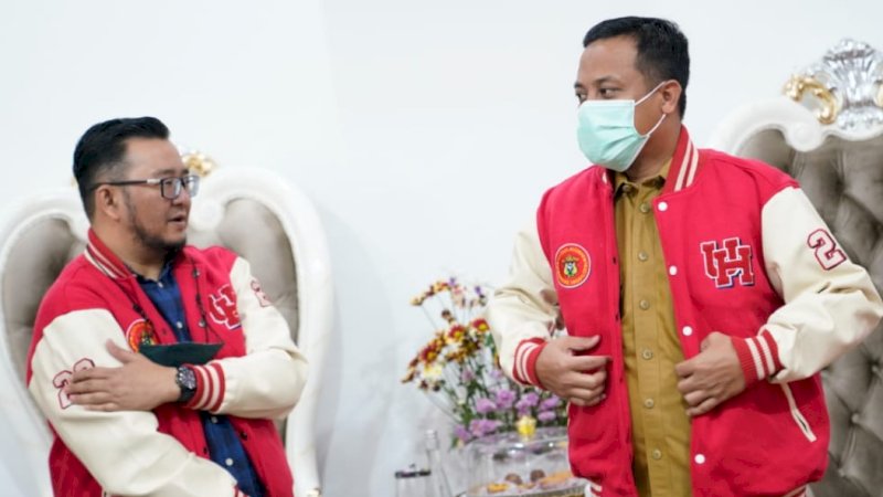 Ketua panitia pelaksana pelantikan, Irwan Ade Saputra, memberikan jaket seragam pengurus kepada Gubernur Sulsel, Andi Sudirman Sulaiman, untuk dipakai secara simbolis dan foto bersama. 