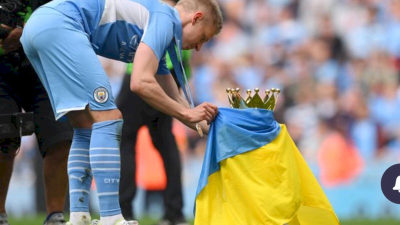 Zinchenko terlihat mengibarkan bendera Ukraina di atas trofi Liga Inggris ( Gambar: Gambar Getty)