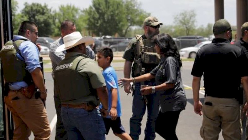 Petugas keamanan mengevakuasi para guru dan murid saat insiden penembakan di Robb Elementary School, Texas, Amerika Serikat (AS), Selasa siang (24/5/2022) waktu setempat. (Foto: Reuters)