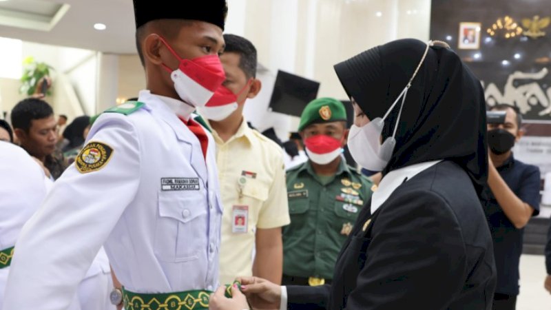 Wakil Wali Kota (Wawali) Makassar, Fatmawati Rusdi, menggantikan posisi orang tua calon paskibraka yang berhalangan hadir saat prosesi pengukuhan di Baruga Anging Mammiri, Senin (15/8/2022).