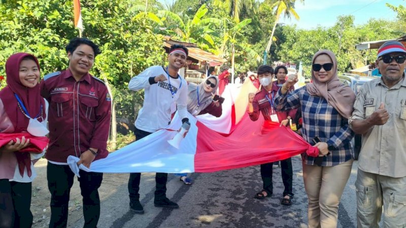 Wakil Ketua DPRD Jeneponto, Irmawati (kedua kanan), bersama warga di Desa Kapita, Kecamatan Bangkala, membentangkan bendera merah putih sepanjang 77 meter. 