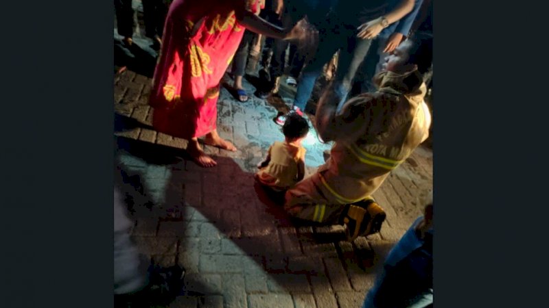 Personel Damkar Makassar bersama balita yang diselamatkan dalam kebakaran di kawasan Pasar Toddopuli, Kecamatan Panakkukang, Minggu dini hari (28/8/2022).