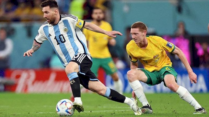 Lionel Messi melewati pemain Australia Kye Rowles pada Babak 16 Besar Piala Dunia 2022 antara Argentina vs Australia di Stadion Ahmad bin Ali, Al Rayyan, Qatar, 3 Desember 2022. REUTERS/Pedro Nunes