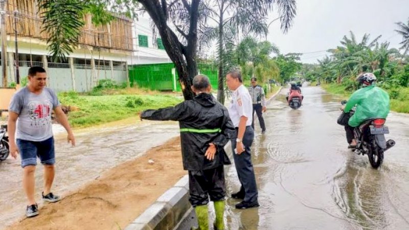 Bupati Wajo, Amran Mahmud, saat meninjau kondisi ruas jalan Jalan Sawerigading, Kecamatan Tempe, Rabu (4/1/2023). Tampak air meluap ke badan jalan.