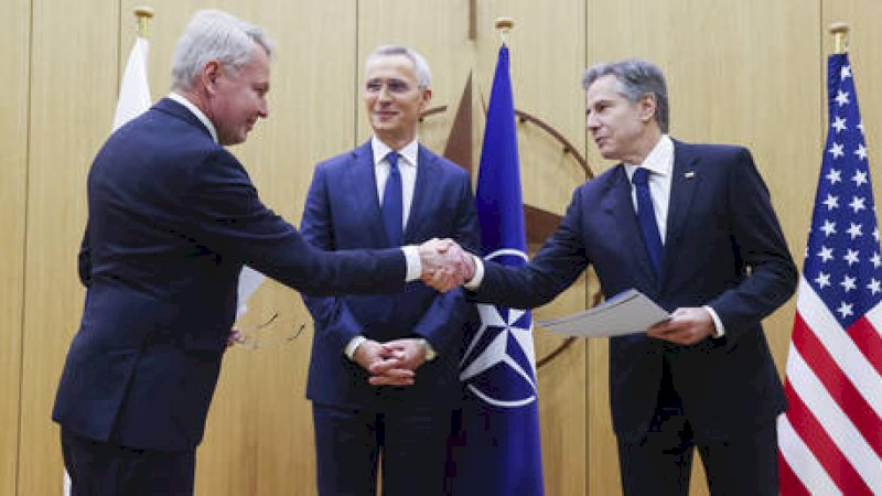 Menteri Luar Negeri Finlandia Pekka Haavisto, kiri, menyerahkan dokumen aksesi negaranya kepada Menteri Luar Negeri Amerika Serikat Antony Blinken, kanan, dalam pertemuan para menteri luar negeri NATO di markas NATO di Brussels, Selasa, 4 April 2023. (JOHANNA GERON /  POOL / AFP)