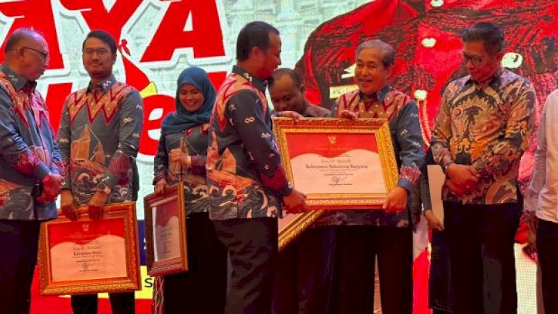 Bupati Sidrap, Dollah Mando (kanan), saat menerima piagam Penghargaan Pembangunan Daerah (PPD) tahun 2023 dari Gubernur Sulsel, Andi Sudirman Sulaiman, pada pembukaan Pekan Raya Sulsel di Wisma Negara, Center Point of Indonesia (CPI), Makassar, Senin (28/8/2023) malam. (Foto: Pemkab Sidrap)