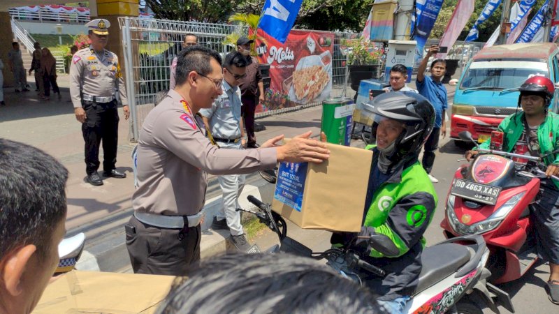 Dirlantas Polda Sulsel Kombes Pol I Made Agus Prasatya saat menyerahkan paket sembako di samping Lapangan Karebosi pada Rabu 13 September 2023. (Dok Rakyatku)