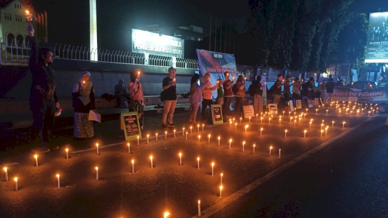 Aliansi Perdamaian Gelar Aksi damai  dengan membakar lilin serta membentakan spanduk yang bertuliskan "Peace For Palestina", di Monumen Mandala,  Jalan Jend. Sudirman, Kota  Makassar, Kamis (19/10/2023) malam. (Foto: Usman Pala/Rakyatku.com)