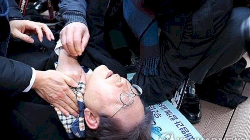 Lee Jae-myung, pemimpin oposisi utama Partai Demokrat, berbaring setelah dia diserang oleh penyerang di sisi kiri lehernya saat berkunjung ke lokasi pembangunan bandara di Pulau Gadeok di lepas pantai tenggara kota pelabuhan Busan pada 2 Januari 2024. (Foto: Yonhap)