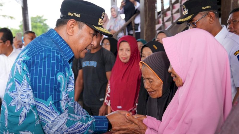 Pj Gubernur Sulsel, Bahtiar Baharuddin (kiri), saat menyalurkan bantuan pangan dari pemerintah pusat berupa beras 10 kg untuk Keluarga Penerima Manfaat (KPM) di Kabupaten Takalar, Rabu (31/1/2024). (Foto: Pemprov Sulsel)