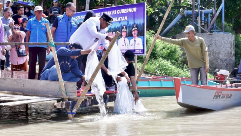 Pj Gubernur Sulsel, Bahtiar Baharuddin, saat menebar bibit ikan di Danau Tempe, Kabupaten Wajo, Jumat (9/2/2024). (Foto: Pemprov Sulsel)