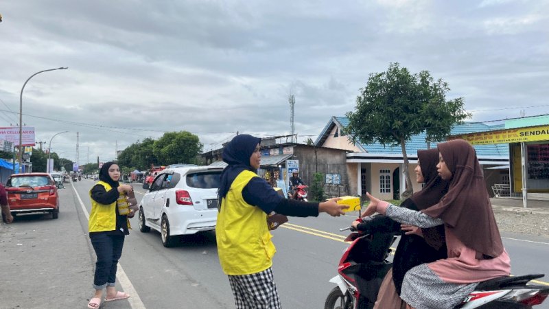 karyawan browcyl sedang membagikan flyer berisi promo opening kepada pengguna jalan di Belopa