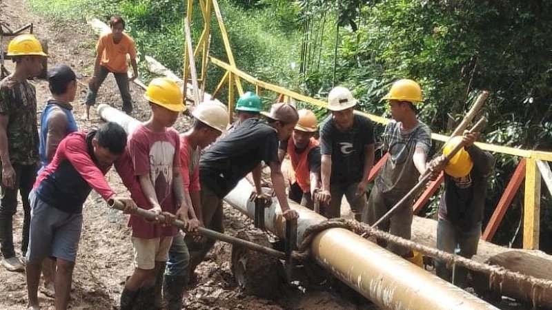 Petugas PLN bersama warga lokal bergotong royong untuk memobilisasi tiang listrik ke Desa Wawosunggu, Kabupaten Konawe Selatan.