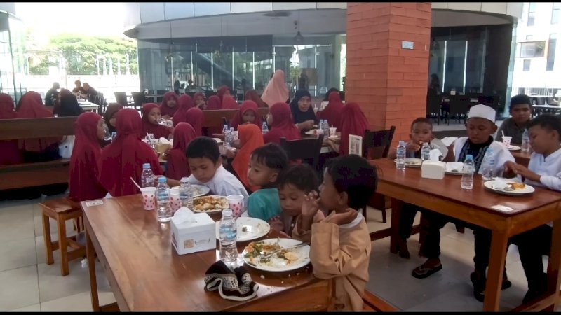 puluhan anak panti asuhan sedang menikmati jamuan kasih