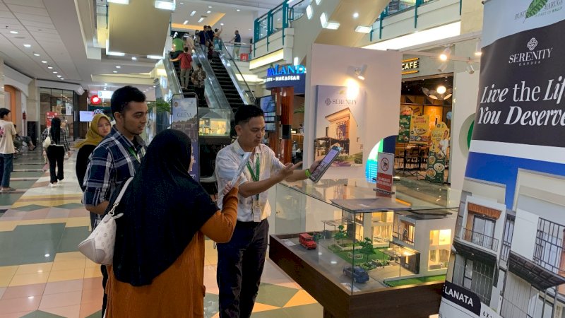 Pengunjung Mal Ratu Indah sedang memperhatikan brosur Serenity Garden 