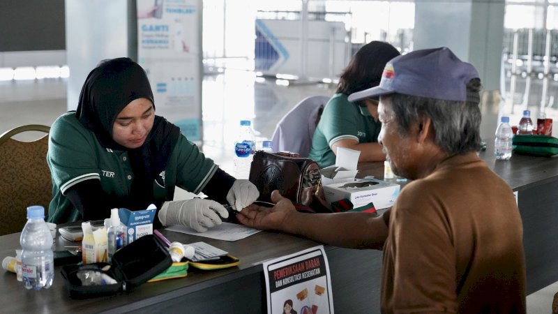 Seorang Buruh atau Tenaga Kerja Bongkar Muat (TKBM) sedang melakukan pemeriksaan 