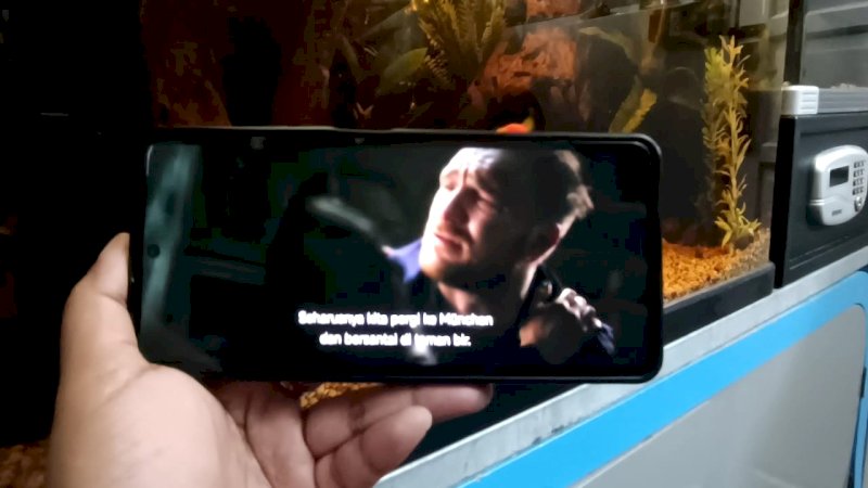 Pelanggan sedang streaming film  action berjudul "Brick" menggunakan perangkat HP