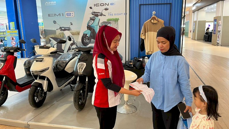 Sales menjelaskan  ke pengunjung keuntungan menggunakan motor listrik dan teknologi yang disematkan di Motor listrik keluaran Astra Motor 