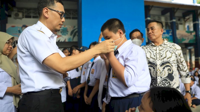 Sekda Kota Makassar Zulkifli Nanda saat membagikan masker ke anak sekolah.