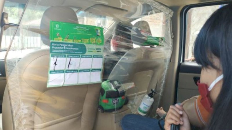 GrabCar Protect dilengkapi dengan sekat pelindung di belakang pengemudi. Juga disediakan hand sanitizer dan tisu.