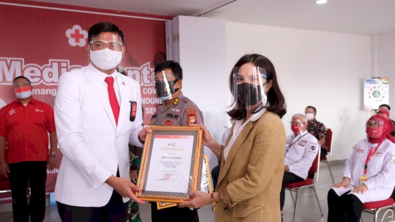 Ketua PMI Sulsel Adnan Purichra Ichsan saat memberikan penghargaan kepada Direktur Utama Bank Sulselbar Irmayanti Sultan yang selama ini aktif dalam mensupport tugas kemanusiaan PMI Sulsel.