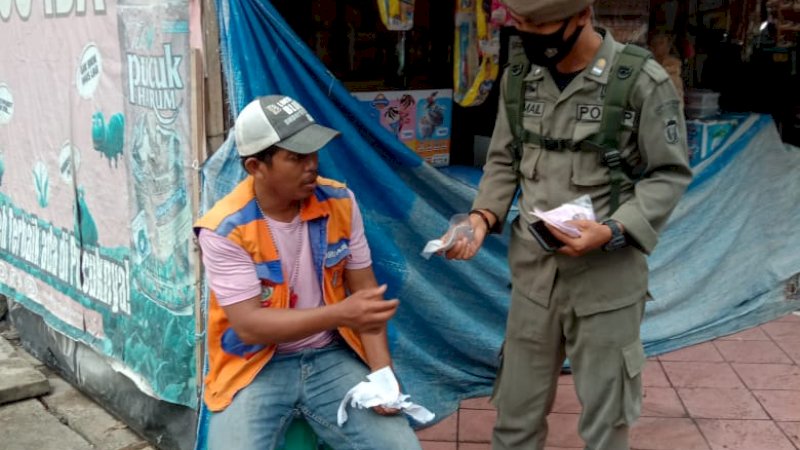 Satpol PP Kota Makassar Bagikan Masker pada warga yang tidak memakai masker saat oprasi yustisi beberapa waktu lalu.