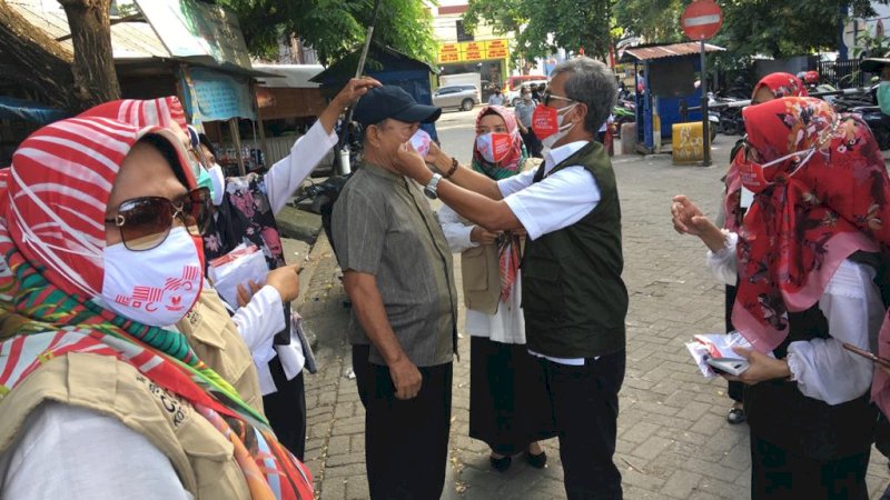 Kadis Kesehatan Makassar,  Agus Djaja Said turut membagikan masker secara gratis di terminal Mallengkeri. (13/11).