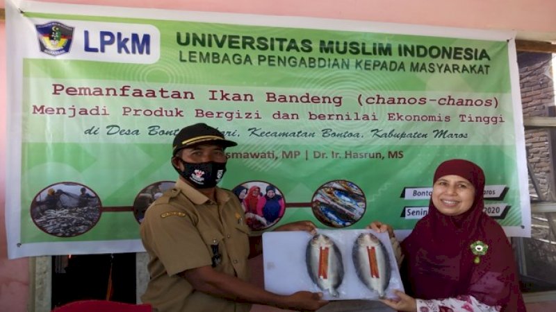 Dosen UMI, Dr Kasmawati menyerahkan hasil olahan ikan bandeng tanpa duri yang telah diberi label kepada Kepala Desa Bonto Bahari, HM Ilyas.