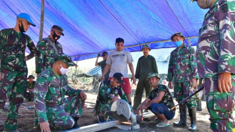 Petugas TNI dan Polri saat membangun hunian sementara (huntara) bagi para pengungsi korban bencana banjir bandang Luwu Utara.